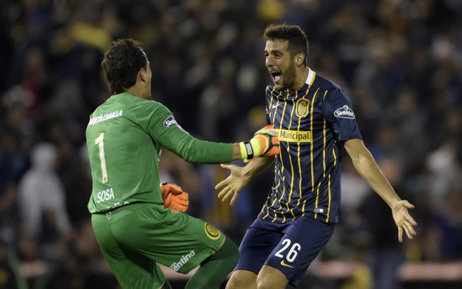 Argentina's Rosario Central goalkeeper Sebastian Sosa (L) and defender Esteban Burgos celebrate the goal scored by teammate forward Marco Ruben (out of frame) during their Copa Libertadores 2016 round before the quarterfinals second leg football match at the "Gigante de Arroyito" stadium in Rosario, Santa Fe, Argentina, on May 5, 2016. / AFP / JUAN MABROMATA        (Photo credit should read JUAN MABROMATA/AFP/Getty Images)
